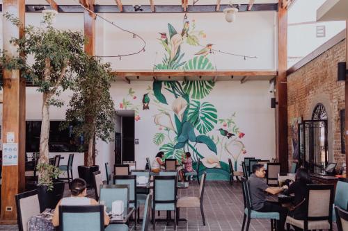 a mural of flowers on the wall of a restaurant at Hotel Dunn Inn in San José