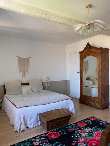 Coursan的住宿－Le logis blanc bed&breakfast，一间卧室配有一张大床和镜子