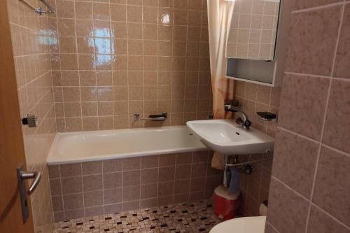 een badkamer met een wastafel, een bad en een toilet bij Haus Panorama Reeling - CharmingStay in Flumserberg