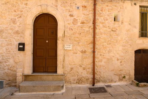 a building with a brown door and stairs next to it at LUXURY ROOM CASSESE in Ceglie Messapica