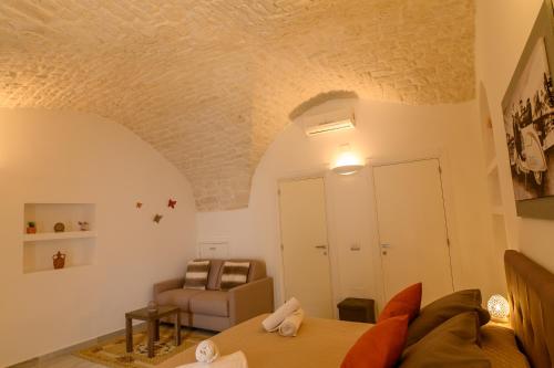 a living room with a couch and a chair at LUXURY ROOM CASSESE in Ceglie Messapica