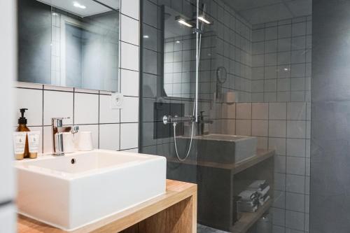 a bathroom with a white sink and a shower at Hôtel Le Collonges TV connecté wifi Netflix in Brive-la-Gaillarde