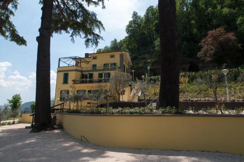 a yellow building with trees in front of it at Hotel Ca' di Gali in Sasso Marconi