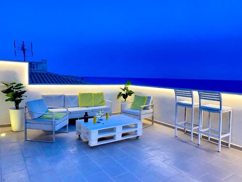 a patio with chairs and a couch and a table at Sa Punta Dúplex Cala Ratjada in Cala Ratjada