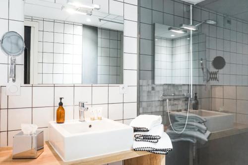 a bathroom with a white sink and a mirror at Hôtel Le Collonges TV connecté wifi Netflix in Brive-la-Gaillarde