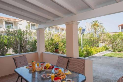 une table avec de la nourriture dessus sur une terrasse dans l'établissement Lollas Apartments Acharavi Corfu, à Acharavi