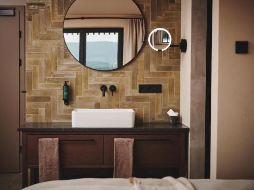 a bathroom with a sink and a mirror at Boutiquehotel DAS ZEITWERT in Deutschlandsberg