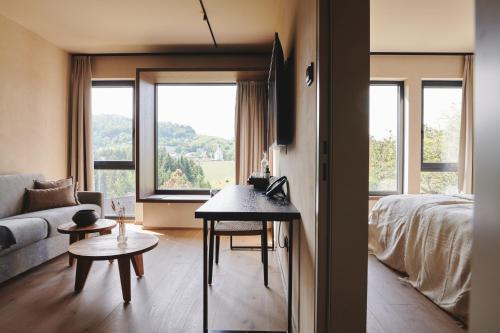 a living room with a bed and a room with a table at Boutiquehotel DAS ZEITWERT in Deutschlandsberg