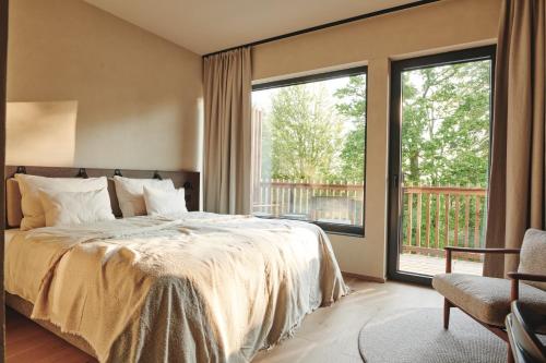 a bedroom with a bed and a large window at Boutiquehotel DAS ZEITWERT in Deutschlandsberg