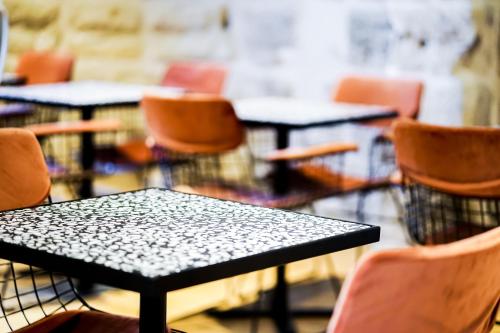a group of tables and chairs in a classroom at Hôtel Le Collonges TV connecté wifi Netflix in Brive-la-Gaillarde