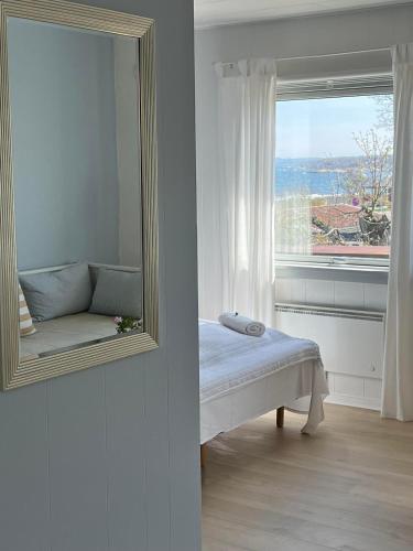 a mirror and a bed in a room with a window at Sandkaas Badehotel in Allinge