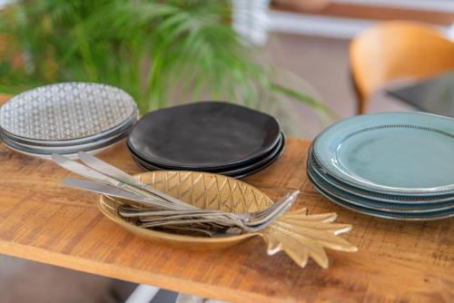 a wooden table with plates and utensils on it at Maison 66, Riviera Hotels in Athens