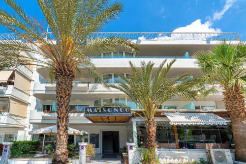a hotel with palm trees in front of it at Maison 66, Riviera Hotels in Athens