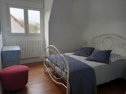une chambre avec un lit avec une couverture bleue et une fenêtre dans l'établissement Maison de Charme en Normandie, à Berneval-le-Grand