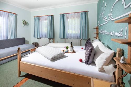 een slaapkamer met een bed en een bank bij Gästehaus Lärcheck Berchtesgaden FeWo Wiesentraum in Berchtesgaden