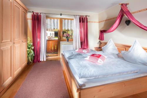 a bedroom with a bed with red curtains at Gästehaus Lärcheck Berchtesgaden FeWo Morgensonne in Berchtesgaden