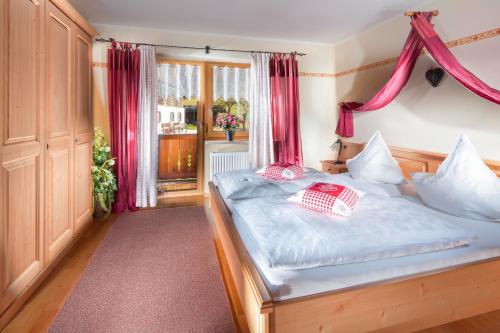 1 dormitorio con 1 cama con cortinas rojas en Gästehaus Lärcheck Berchtesgaden FeWo Morgensonne, en Berchtesgaden