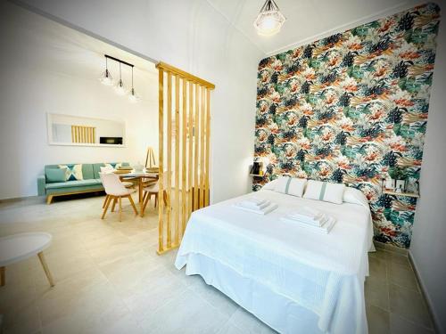 um quarto com uma cama branca e uma parede floral em Apartamentos Guaditania em Mérida