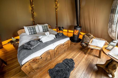 a bedroom with a large bed with towels on it at Scaldersitch Farm Boutique Glamping Tipi with private wood fired hot tub in Sheen