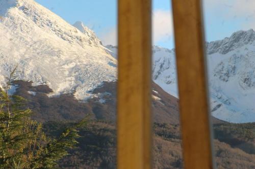 a view of a snow covered mountain from a window at OIKOS in Ushuaia