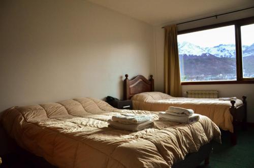 a hotel room with two beds with towels on them at OIKOS in Ushuaia