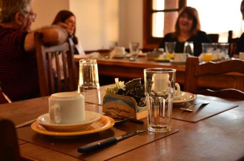 a table with plates and glasses and people sitting at a restaurant at OIKOS in Ushuaia