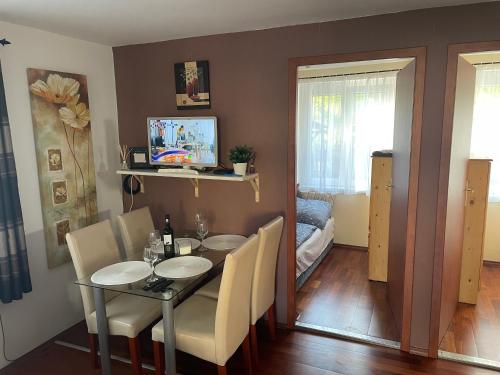 un comedor con mesa y sillas en una habitación en Léda Apartman, en Bogács