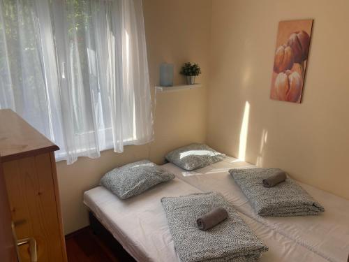 a bed with two pillows on it in a room at Léda Apartman in Bogács