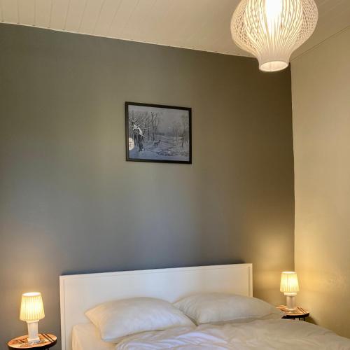 une chambre avec un lit avec un tableau sur le mur dans l'établissement Les Figuiers N°2 - Repos et tranquillité, à La Michelière