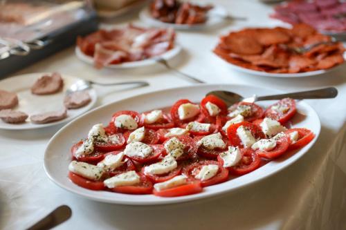 a plate of food on a table with tomatoes at Petrény Borpanzió in Egerszalók