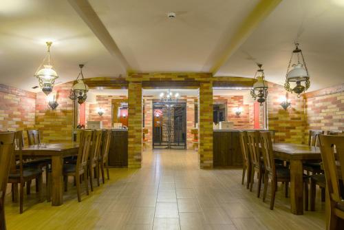 a restaurant with wooden tables and chairs in a room at Petrény Borpanzió in Egerszalók