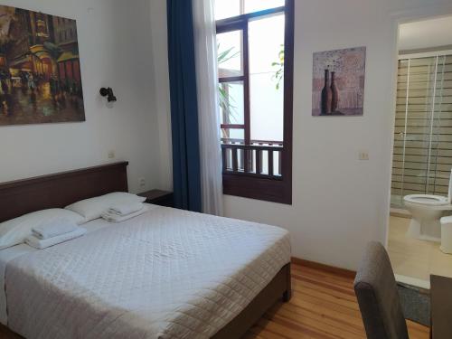 a bedroom with a bed and a bathroom with a window at Sea Front Old Town in Rethymno Town