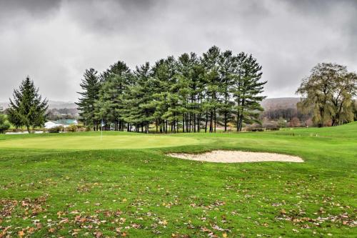 a green golf course with trees and a bunker at Family-Friendly Terra Alta Home with Lake View! in Terra Alta