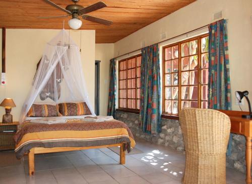 1 dormitorio con 1 cama y ventilador de techo en Kosi Moon Bed and Breakfast en Manguzi