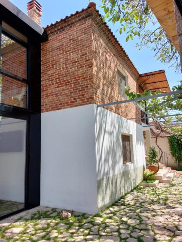 a brick house with a white wall at VILA RIRA - Rrajcë, Shebenik in Përrenjas