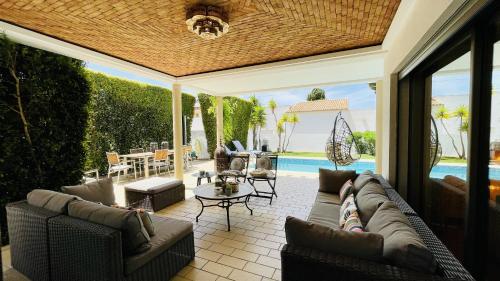a patio with a couch and chairs and a pool at Praia by Check-in Portugal in Albufeira