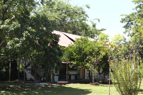 uma casa com árvores em frente a um quintal em Amaya's Hostel em Jaloba