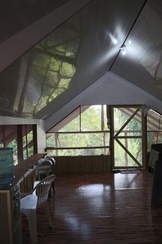 Amaya's Hostel في Jaloba: غرفة ذات سقف شبابيك وارضية خشبية