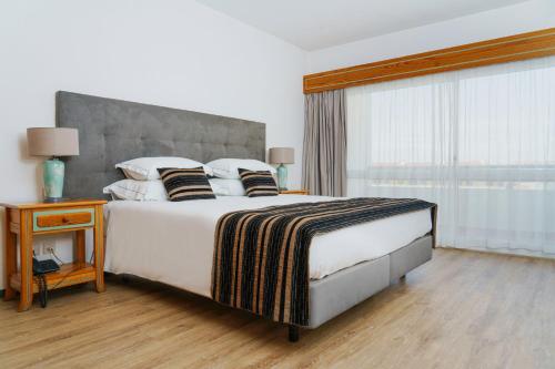 een slaapkamer met een groot bed en een raam bij Luna Hotel da Oura in Albufeira