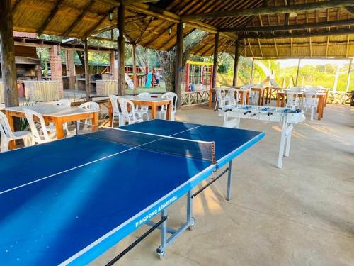 a blue ping pong table in a pavilion with tables and chairs at Confratelli Cabañas in Paso de la Patria