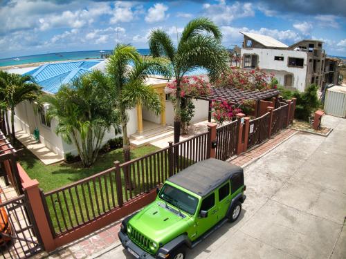 a green truck parked in front of a house at Reflection Y 5 Star Villa in Maho Reef