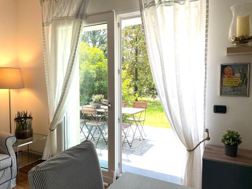 een woonkamer met een deur naar een patio bij MY HUMBLE HOUSE -Appartamento in villa con vista lago in Oggiono