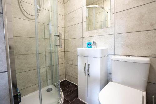 uma casa de banho com um WC e uma cabina de duche em vidro. em No 01 Small Studio flat in Aylesbury town Station em Buckinghamshire