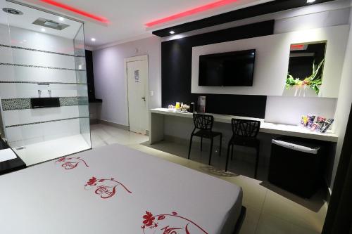 a room with a bed and a table and chairs at Motel Luxury in Votorantim
