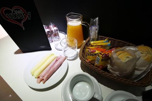 a table with a basket of hot dogs and drinks at Motel Luxury in Votorantim