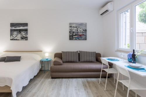 een slaapkamer met een bed, een bank en een tafel bij Apartment R&R in Dubrovnik