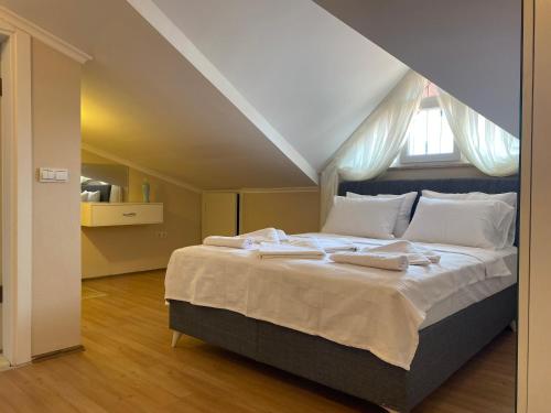 um quarto com uma cama grande e toalhas em Thefamilyapartmentsinfethiye em Fethiye