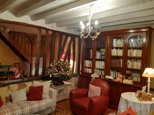 - un salon avec un arbre de Noël et un canapé dans l'établissement les orchidees sauvages, à Touffreville-la-Corbeline