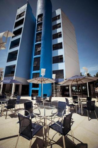 a table and chairs with umbrellas in front of a building at Hotel Espadarte in Iriri