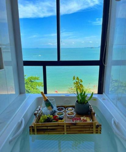 a tray of food in a window with a view of the ocean at Hotel Espadarte in Iriri